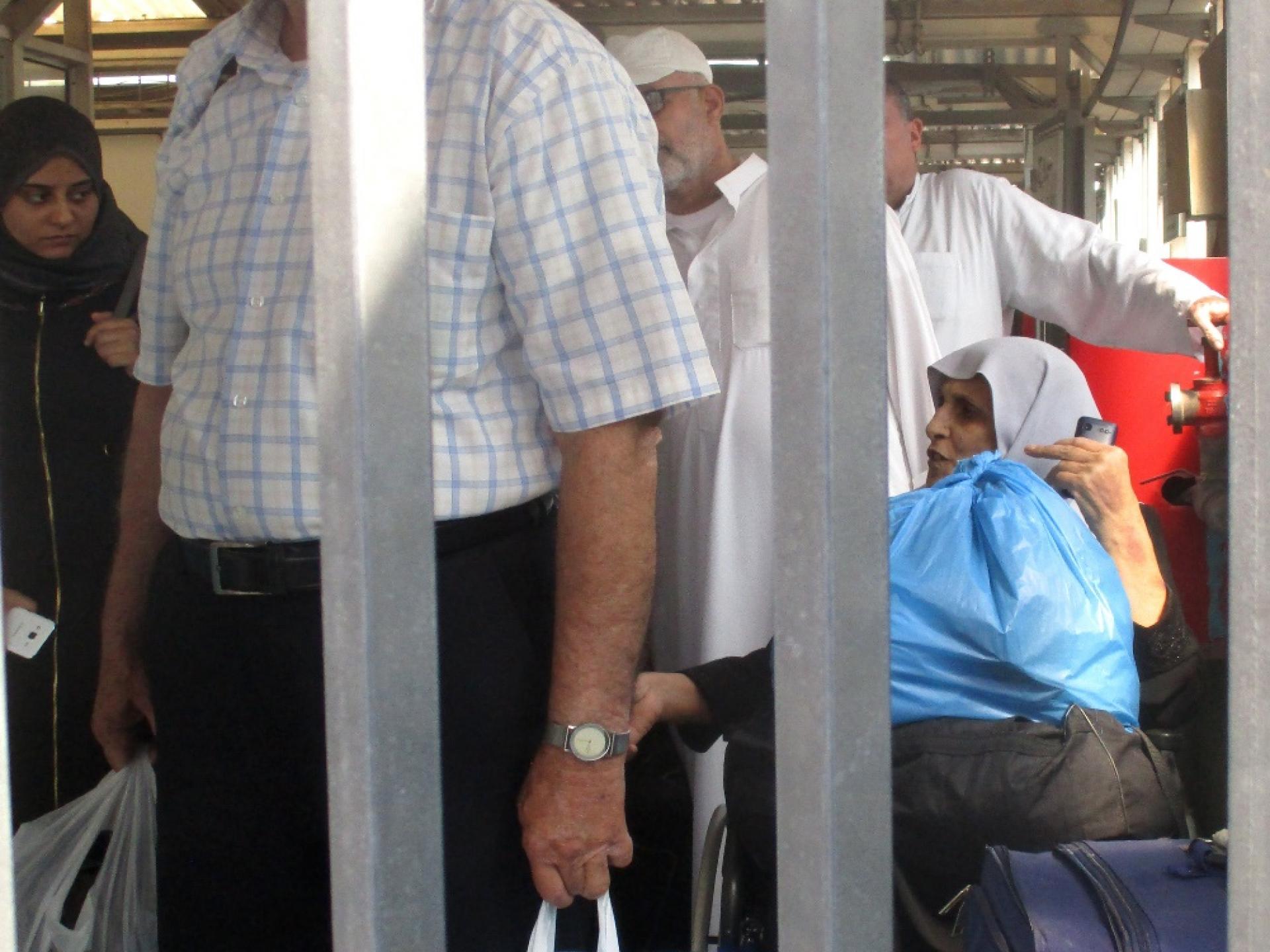 Palestinians wait quietly in order to pass the checkpoint on the way home to Gaza.