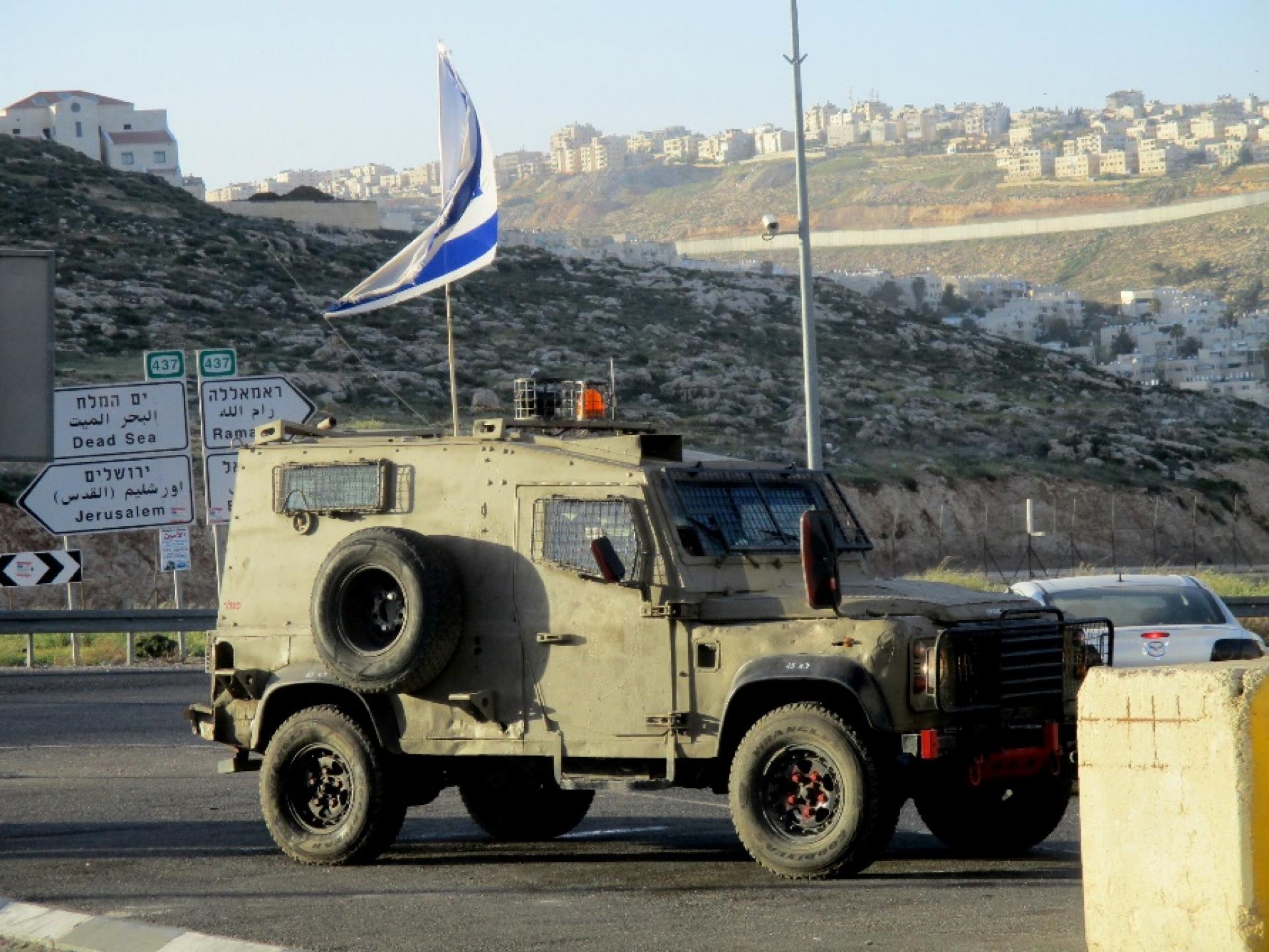 An army vehicle stands at the main entrance to Hizma