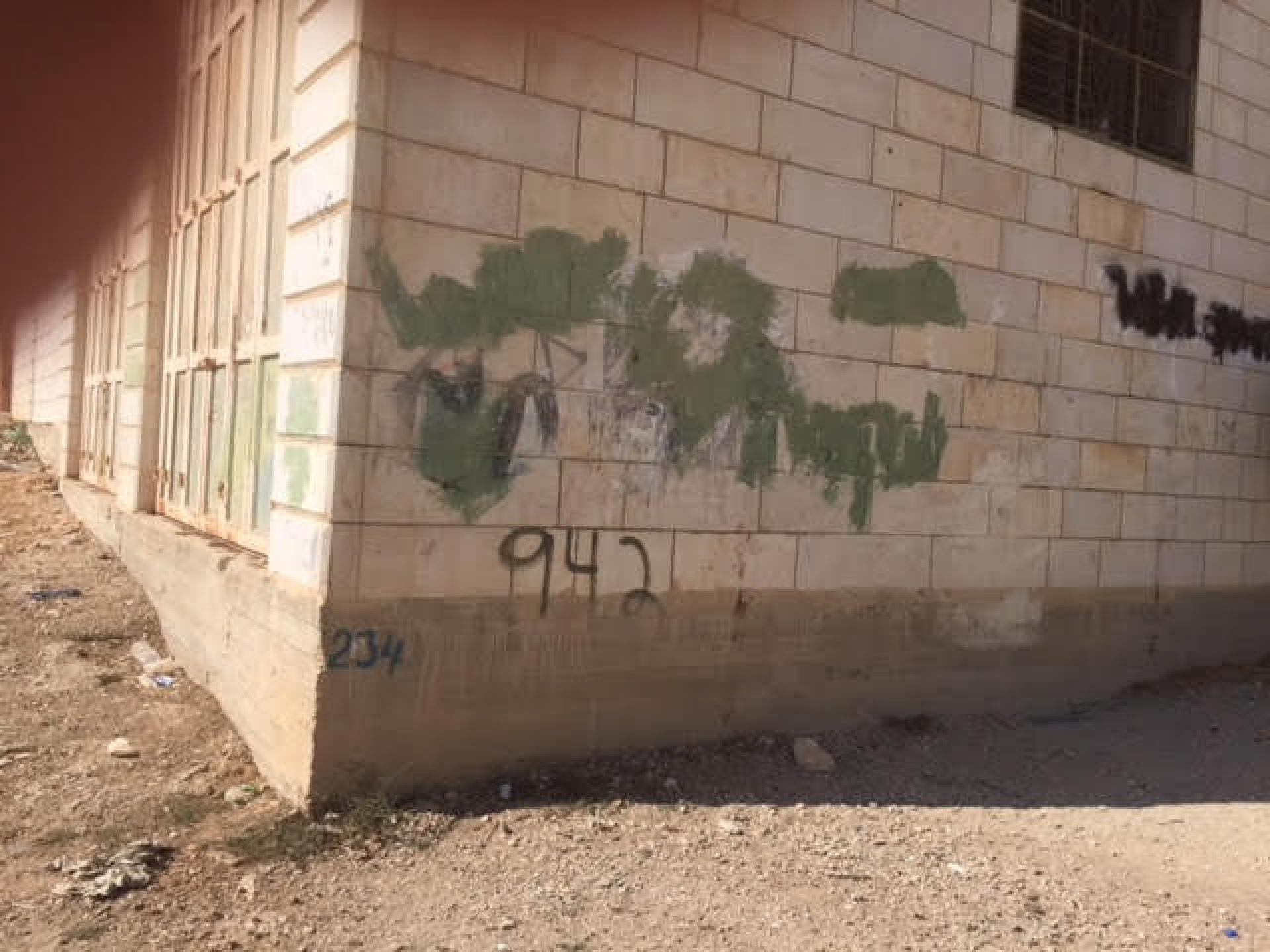 Racist graffiti signs covered with green paint