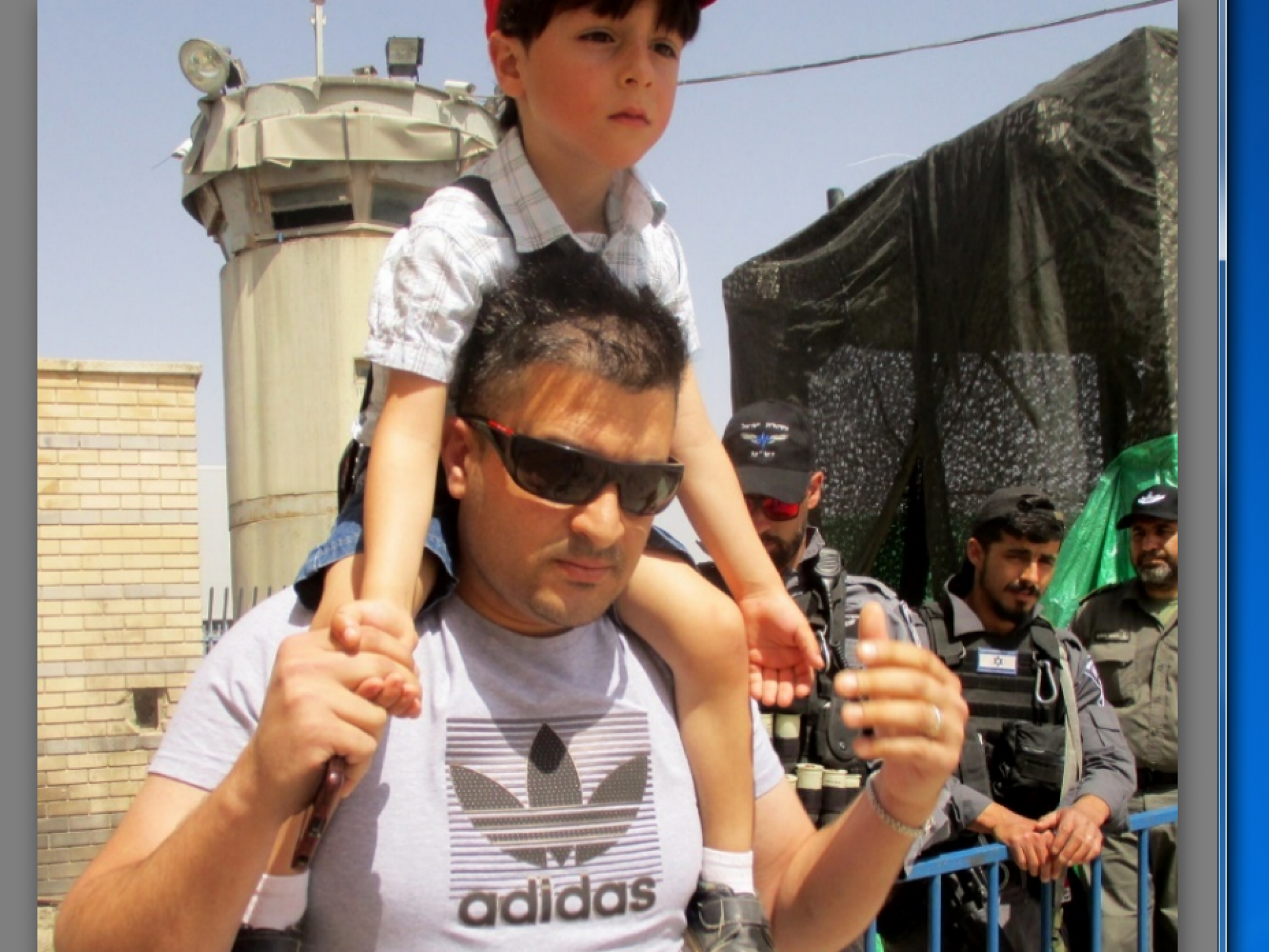 אב ובנו במחסום קלנדיה ביום שישי השני לחודש הרמדאן 