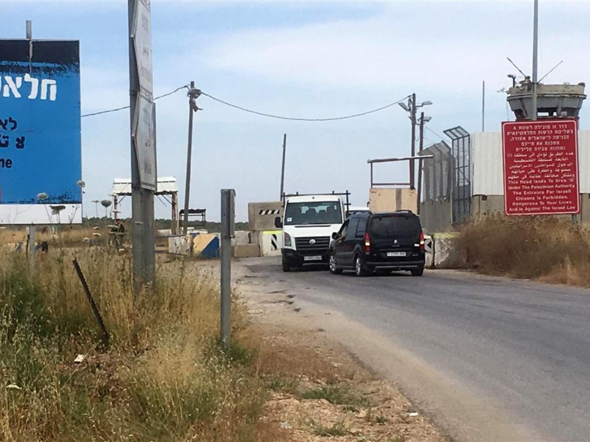 מכוניות תקעות לפני הבטונדות במחסום. לצידו הימני השלט האדום המכריז על סכנה לישראלים