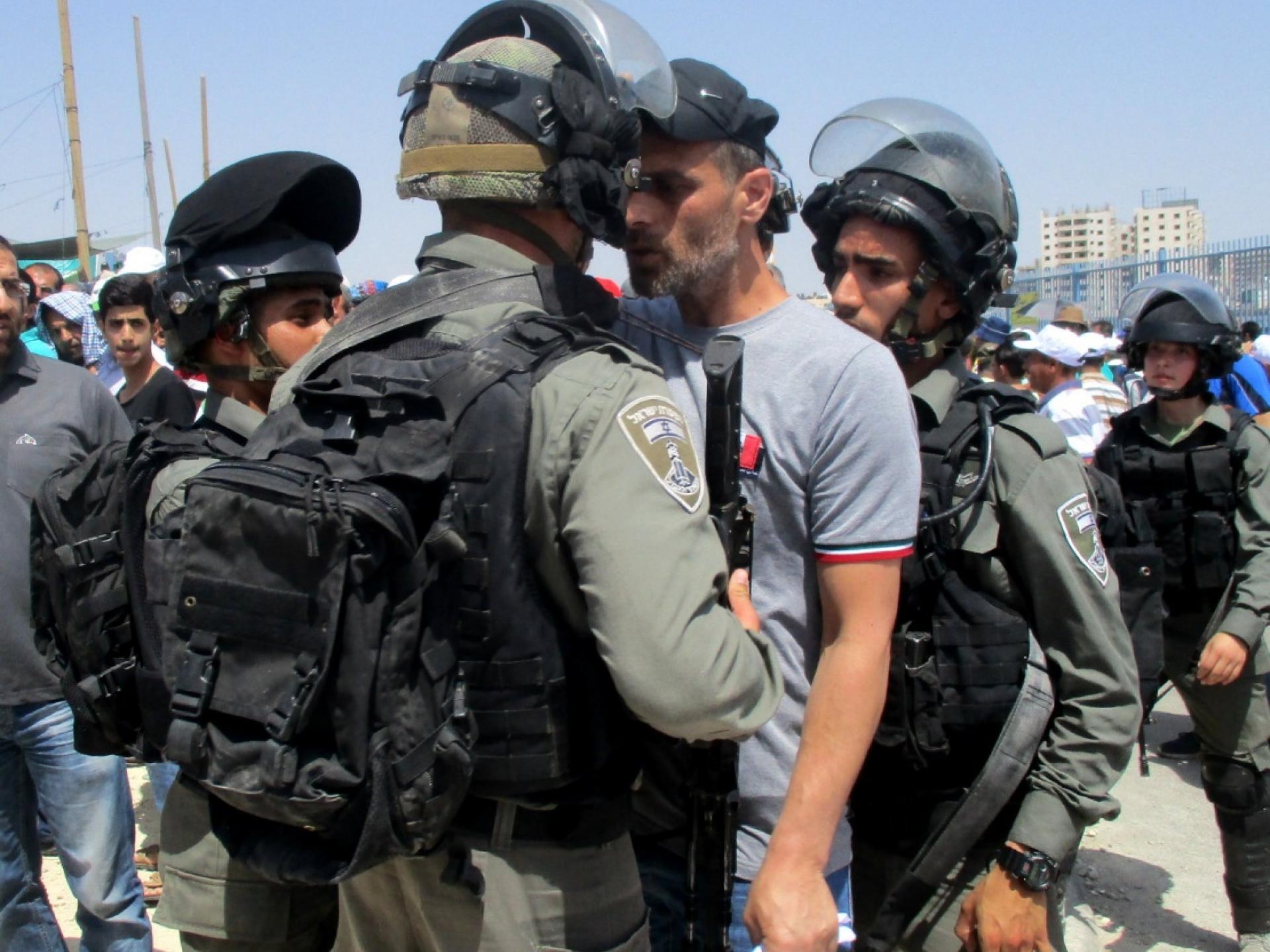 פלסטיני מוקף ע"י שלושה חיילים