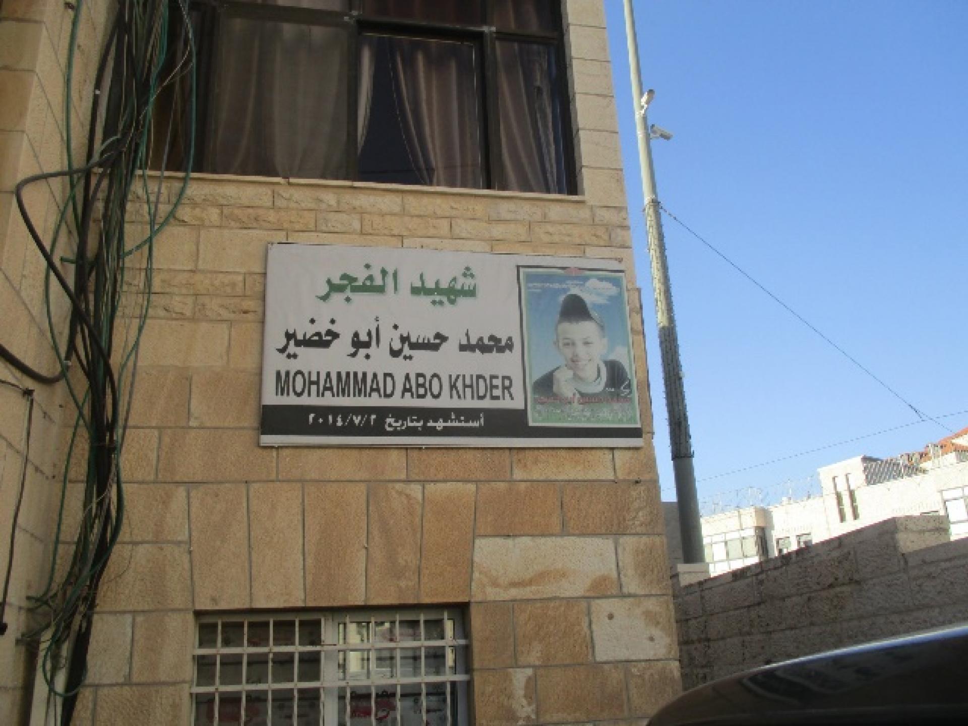 שלט קטן עם תמונת הילד הרצוח, מוחמד אבו-ח'דיר