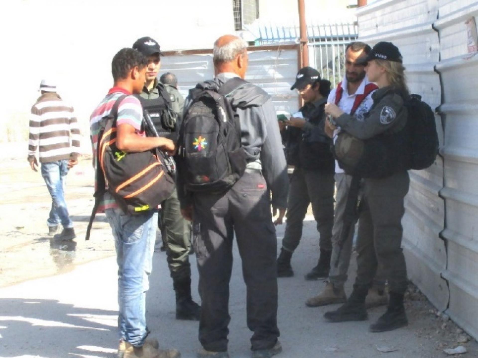 שלושה שוטרי מגב בודקים אישורים מחוץ למחסום