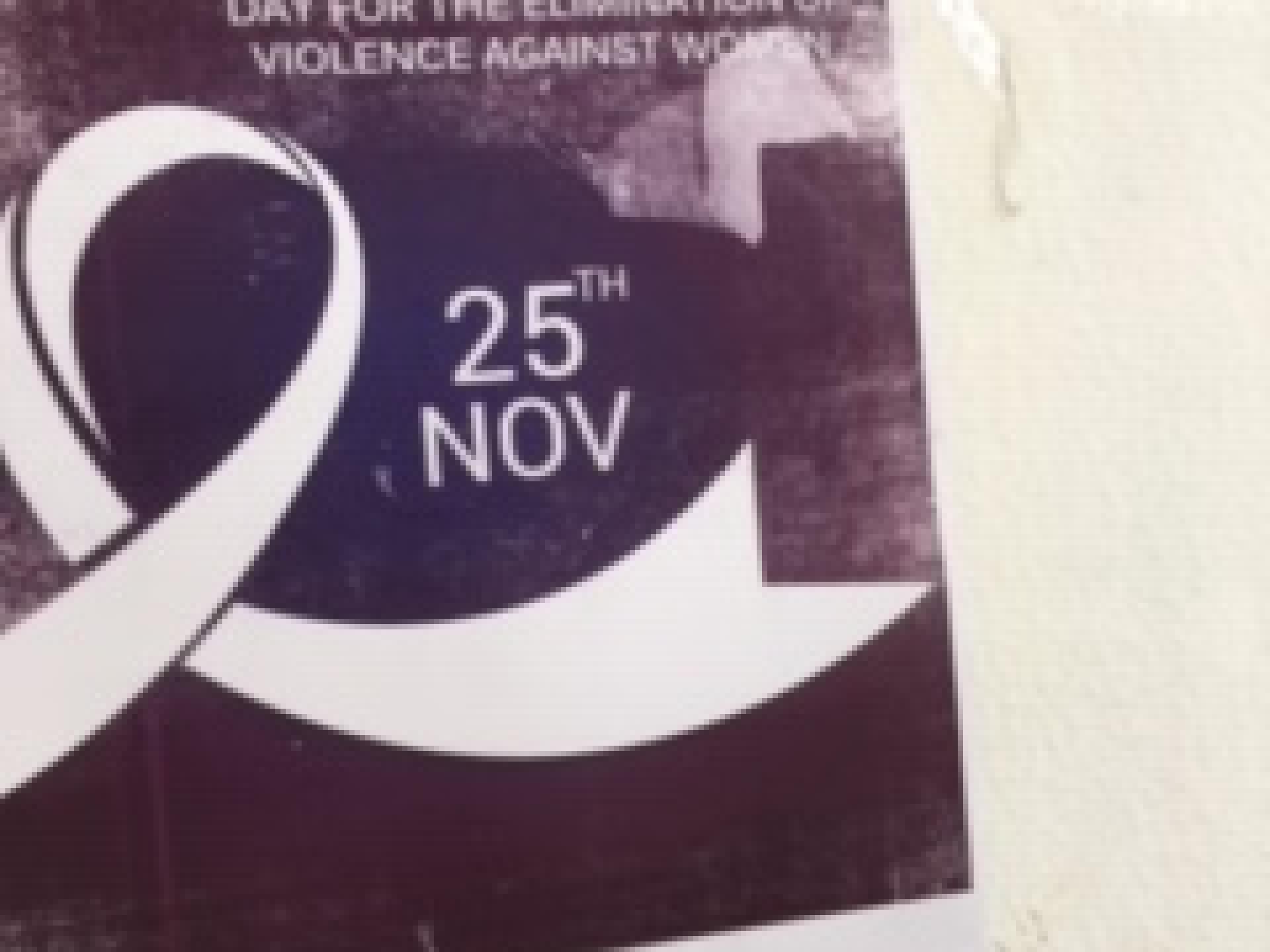 פוסטר על הקיר: "יום בינלאומי למיגור אלימות נגד נשים.”