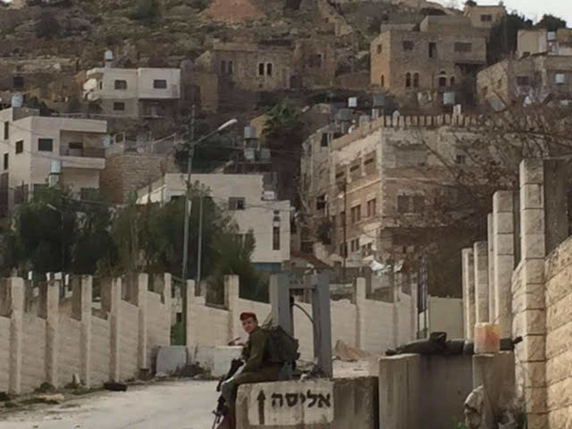 חייל שומר על כיכר גרוס פתחו את השער לשכונת אבו סנאן