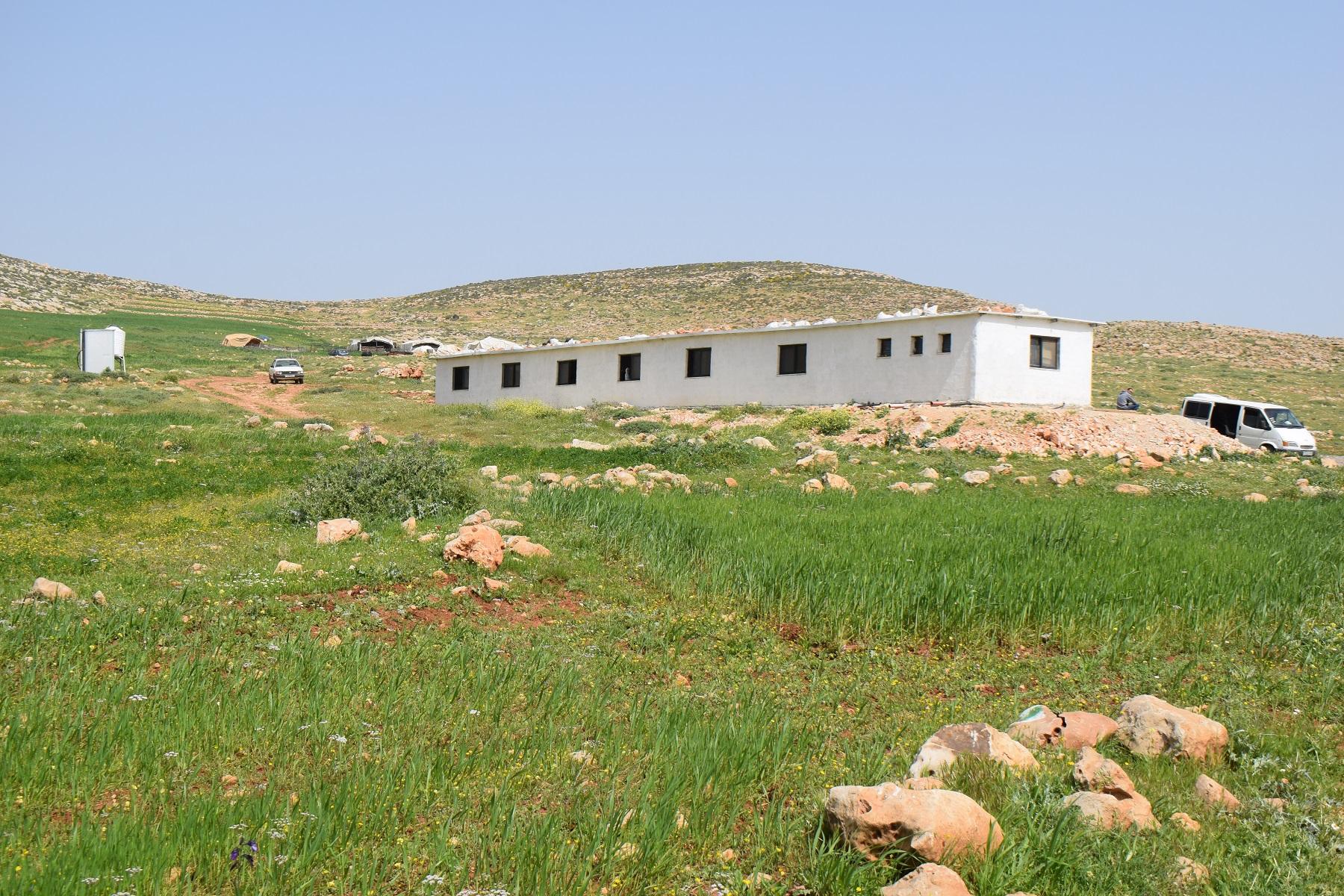 a white building of a school on a hill