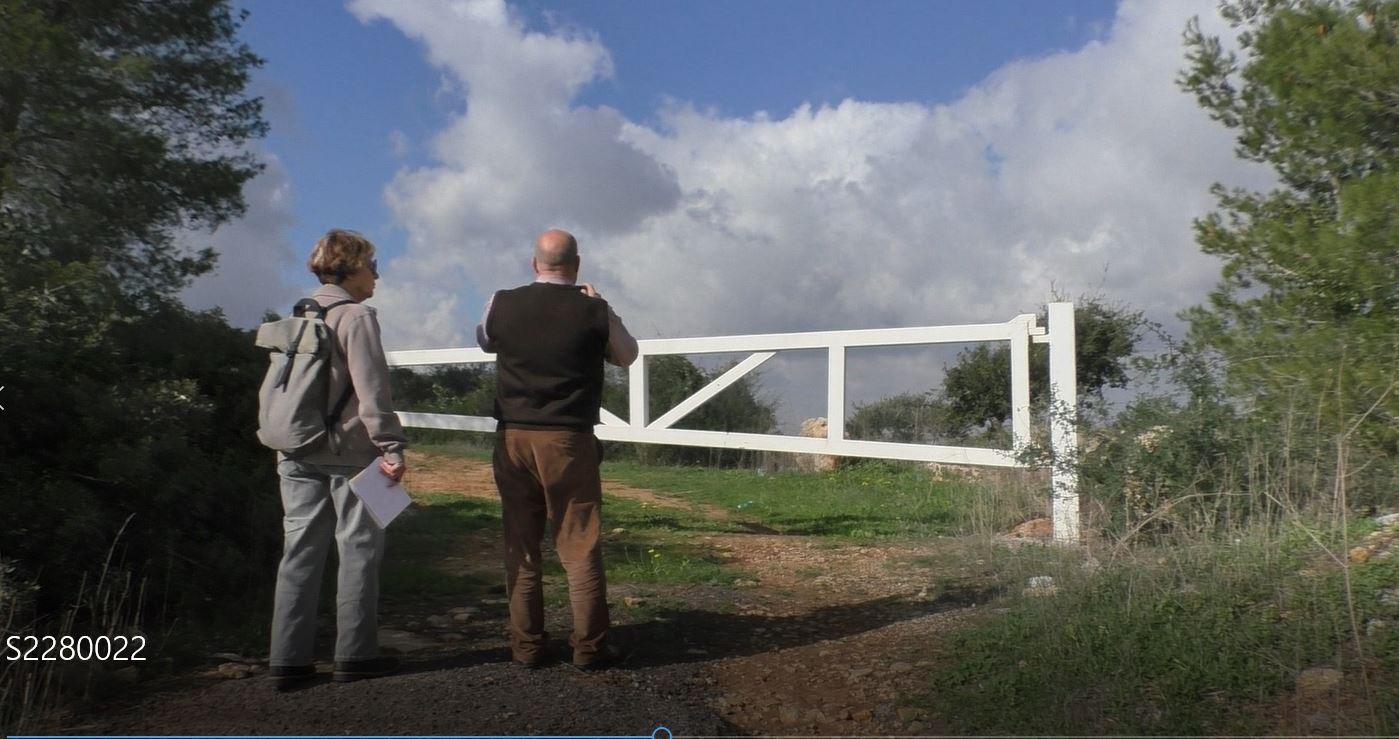  A man and a woman gazing from a closed gate