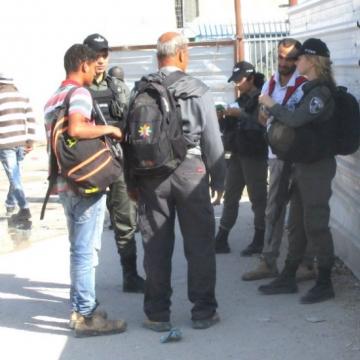 שלושה שוטרי מגב בודקים אישורים מחוץ למחסום