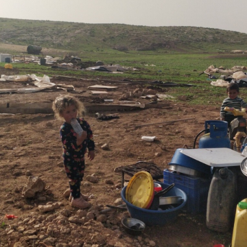 ילדי חומסה משחקים בין הריסות בתיהם ושרידי החפצים שלהם