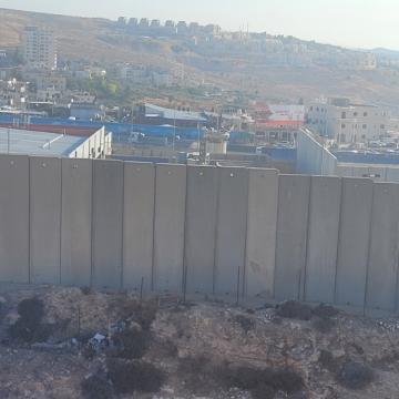 החומות המסתירות את סלילת כביש העיקוף השקוע לישראלים במחסום קלנדיה