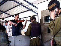 Palestinian plays violin at Israeli checkpoint (image credit: Horit Herman Peled)