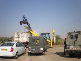 דחפור ומנוף מחרימים ארגזי ירקות מלב שדה פלסטיני