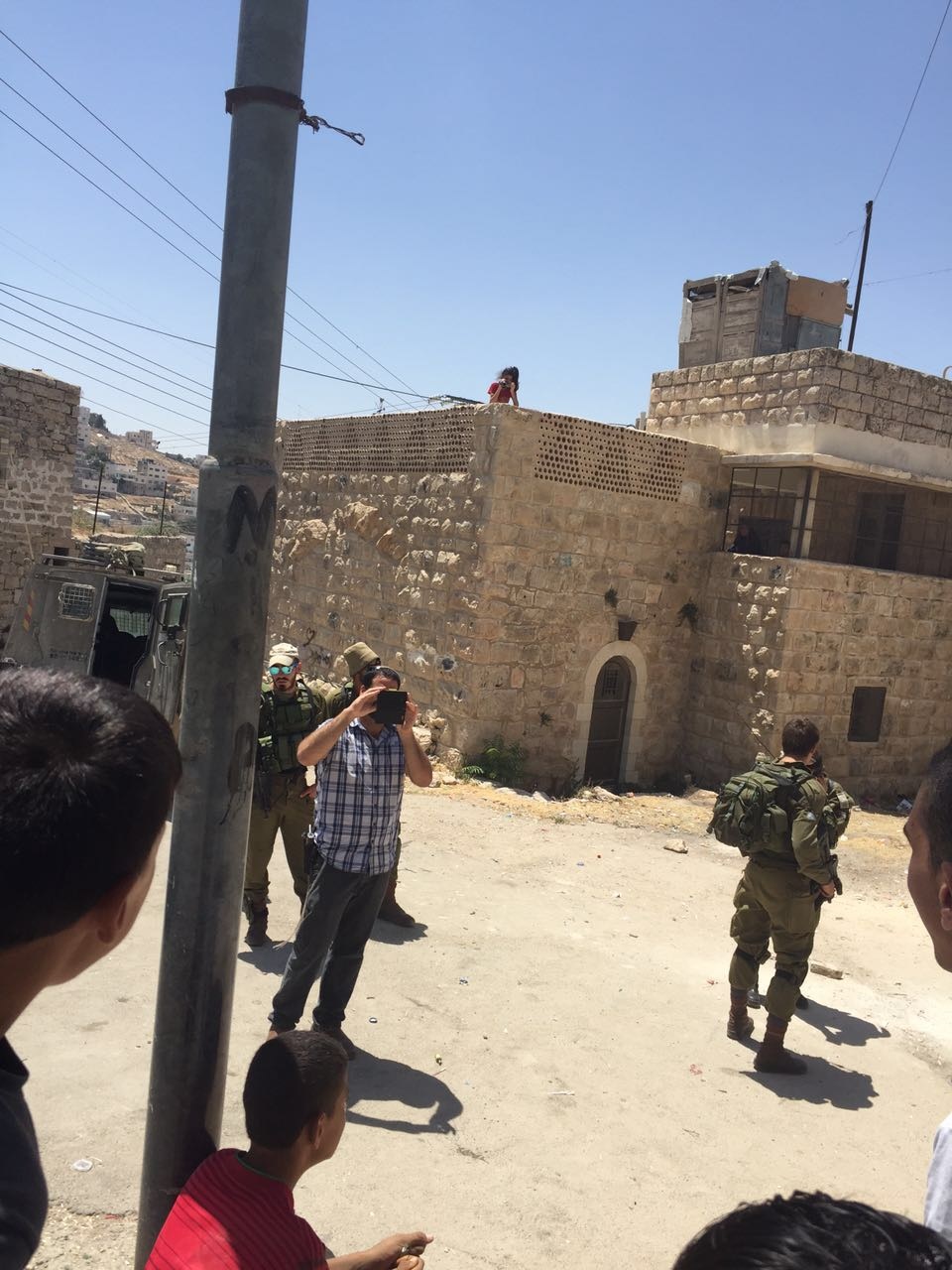 המתנחל חיים מצלם אותי מצלמת אותו כשהוא מכוון את צהל להרוס את התוספת של ע' גה