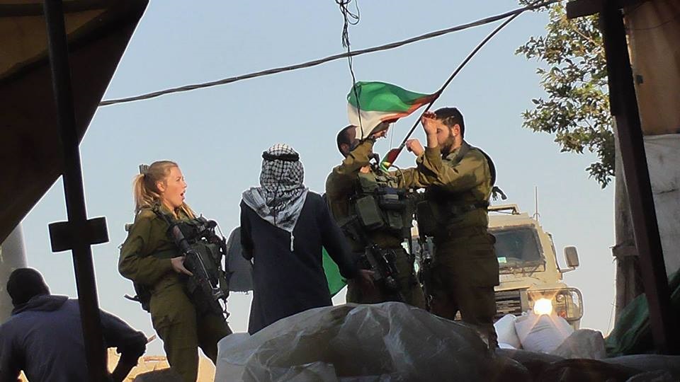 חיילי צבא הכיבוש הנועזים מורידים את הדגל מעל ביתו של זובעה. צילם מחמוד בשאראת