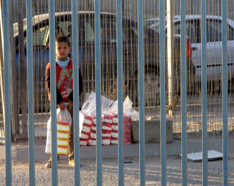 A boy selling tissue paper. Qalandiya. Photographer: Tamar Fleishman. March 5, 2017