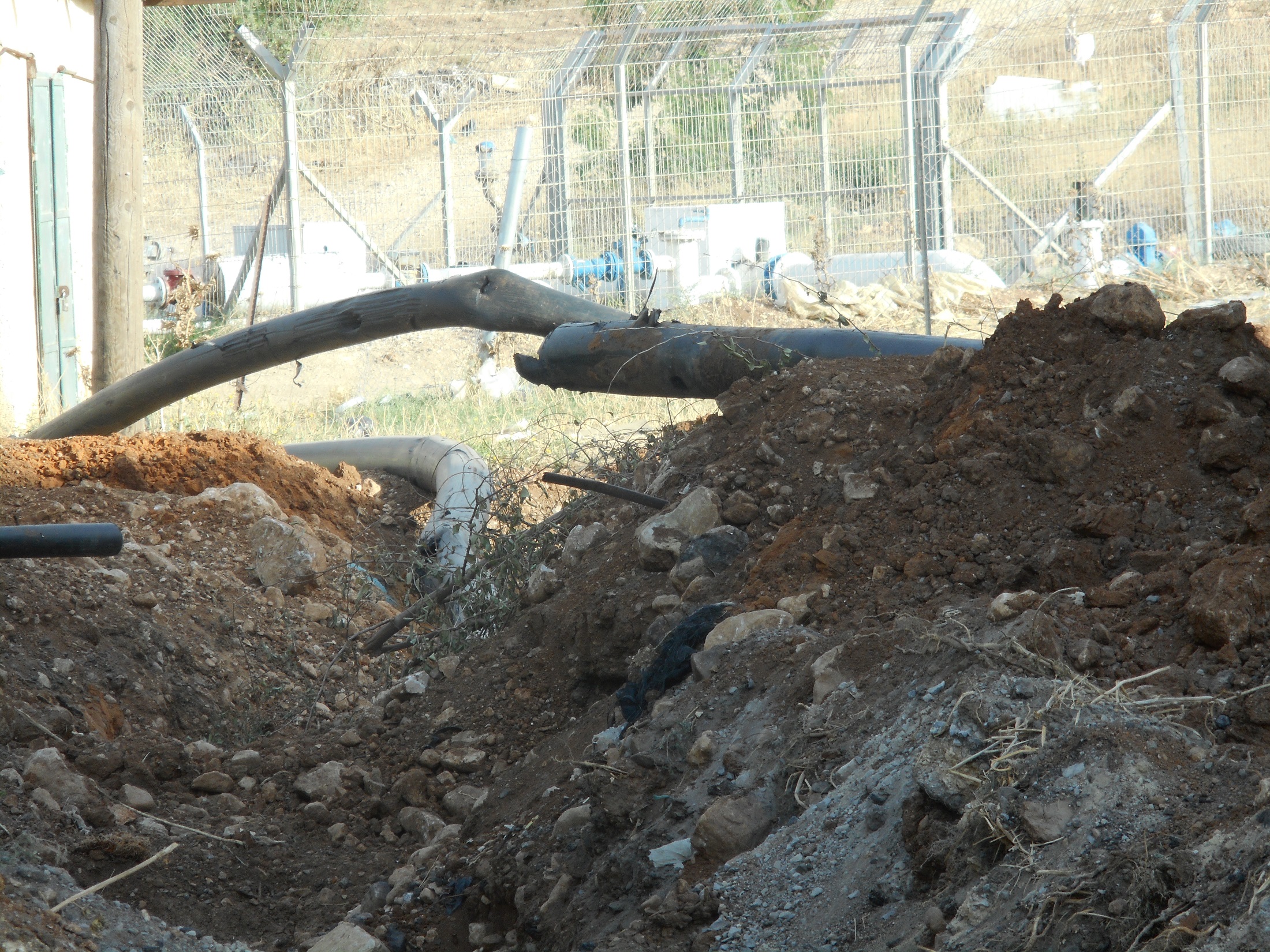 הצנרת החתוכה ומאחוריה משאבת המים של מקורות - בלב העיירה ברדלה 9.5.17.jpg