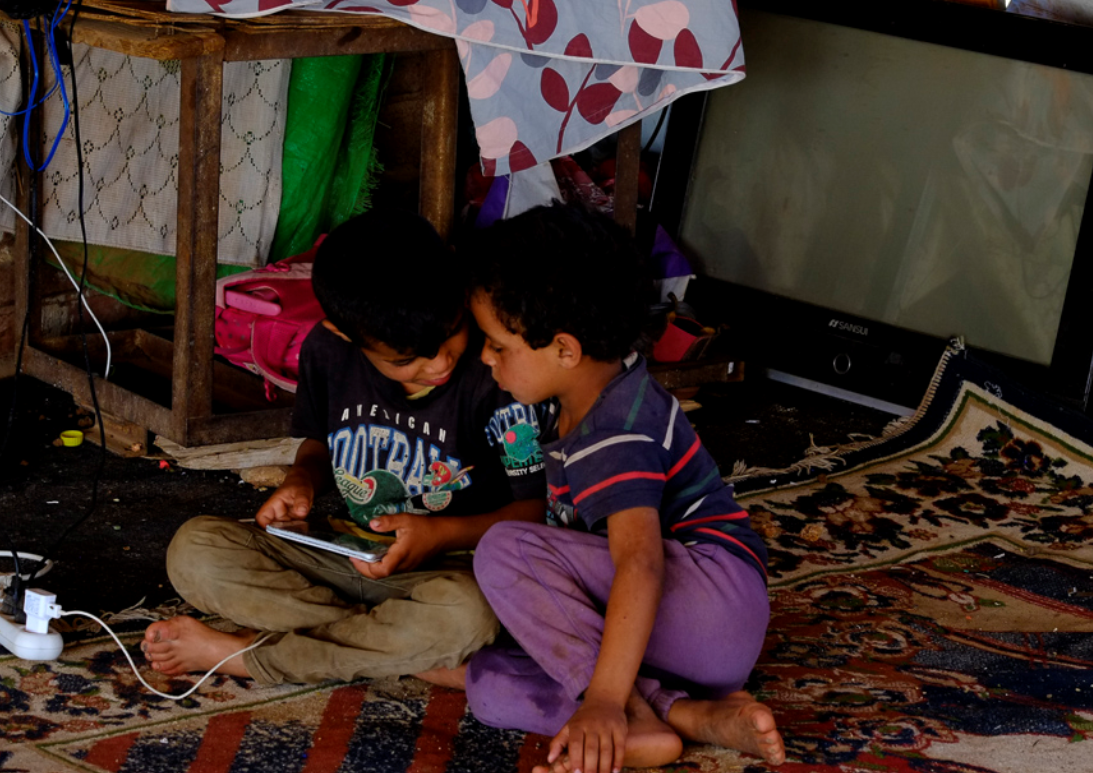 Two of the family's children absorbed in their tablet play