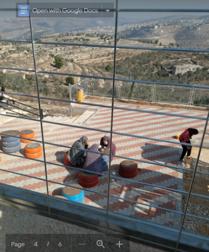 Women have coffee at the lower level of the garden in Nabi Saleh