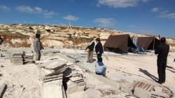 שני אוהלים שמשים ככיתות. אריאלה ומיכל מביטות בהריסות.