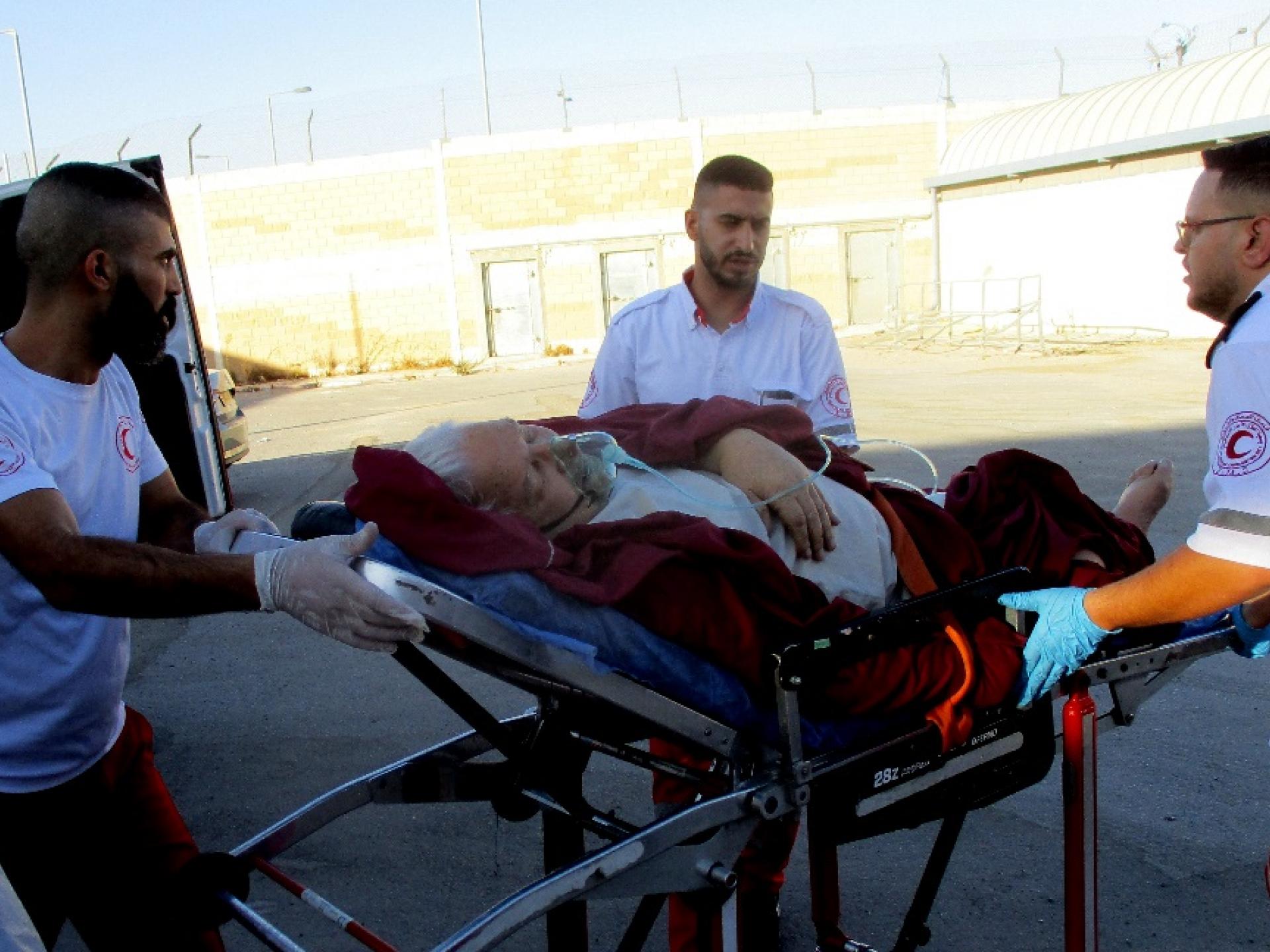 A heart patient is transferred from a Palestinian ambulance to an Israeli ambulance at the Qalandiya checkpoint, October 2022