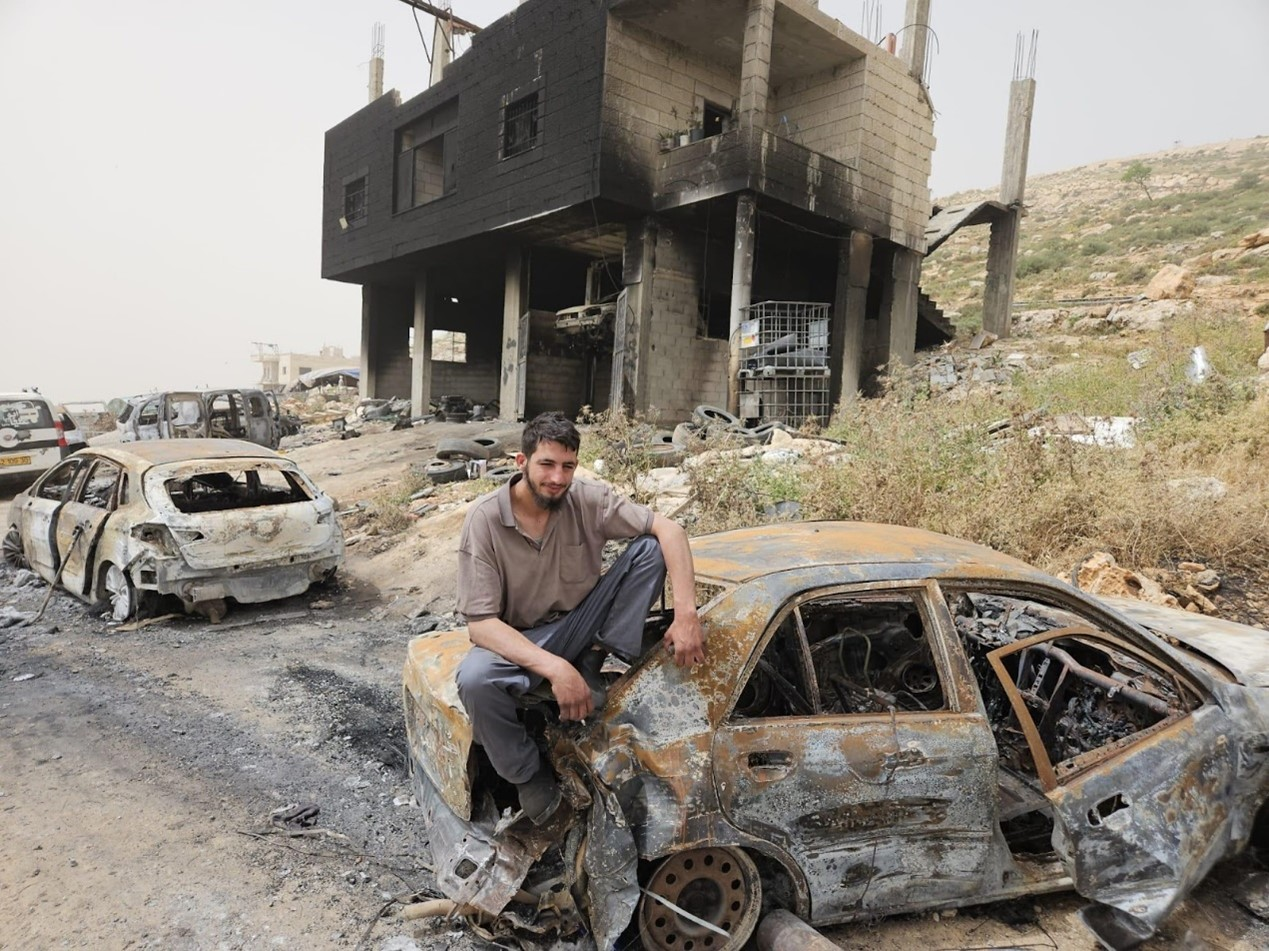 Mughayyir, with the burned cars alongside the burnt house.  Photo: Firas Alami, Yesh Din