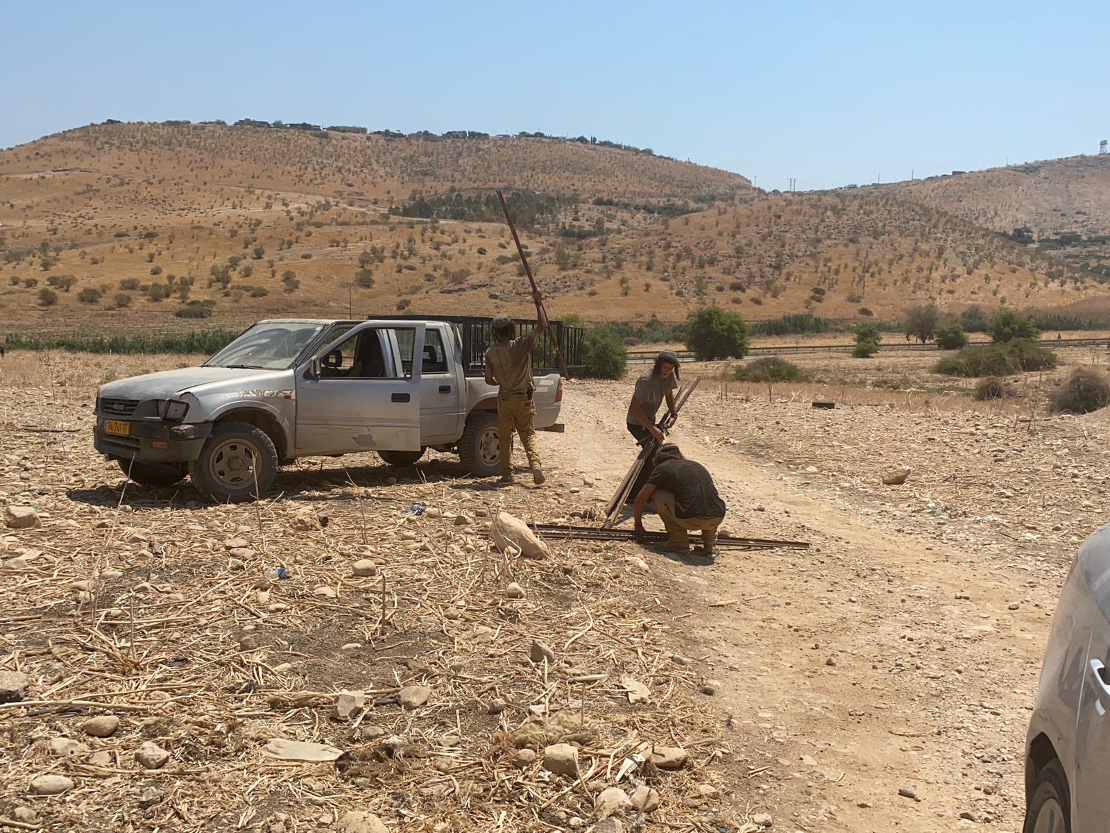 colonists of the Tene Yaroq (Green Basket) outpost on the track leading to Al Farisiya, with metal rods for flags or fence