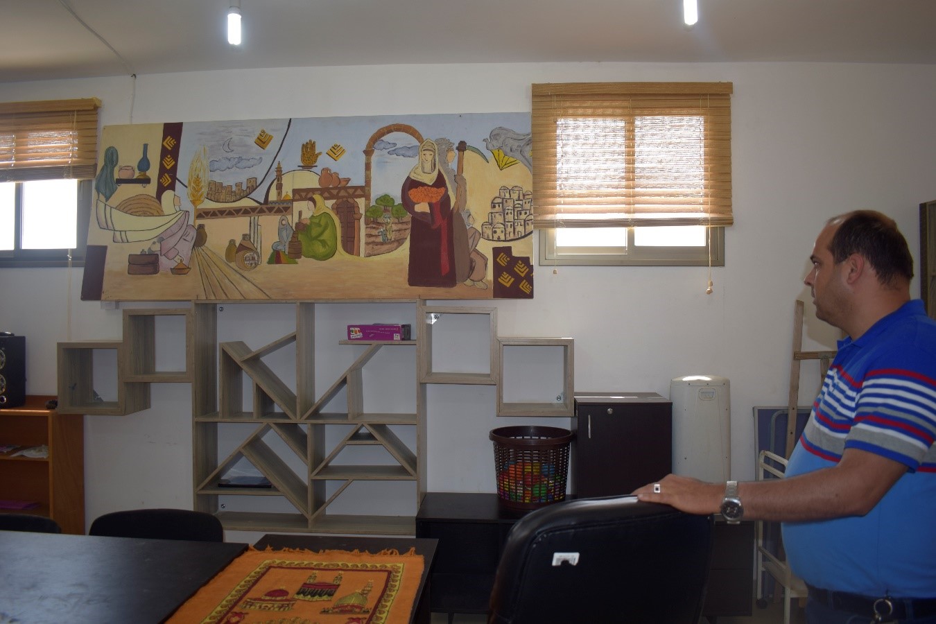 עומר במרכז הקהילתי, הציור שעל הקיר מספר כמו בהגדה של פסח את תלאות הכיבוש. (3.5.17 צילום נורית).jpg