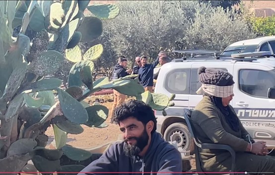 חדידיה: מימין הנאשמת בזריקת אבנים; לשמאלה נאשם ב"משהו"; ברקע מאחור המתנחל מסתחבק עם חיילים ושוטרים