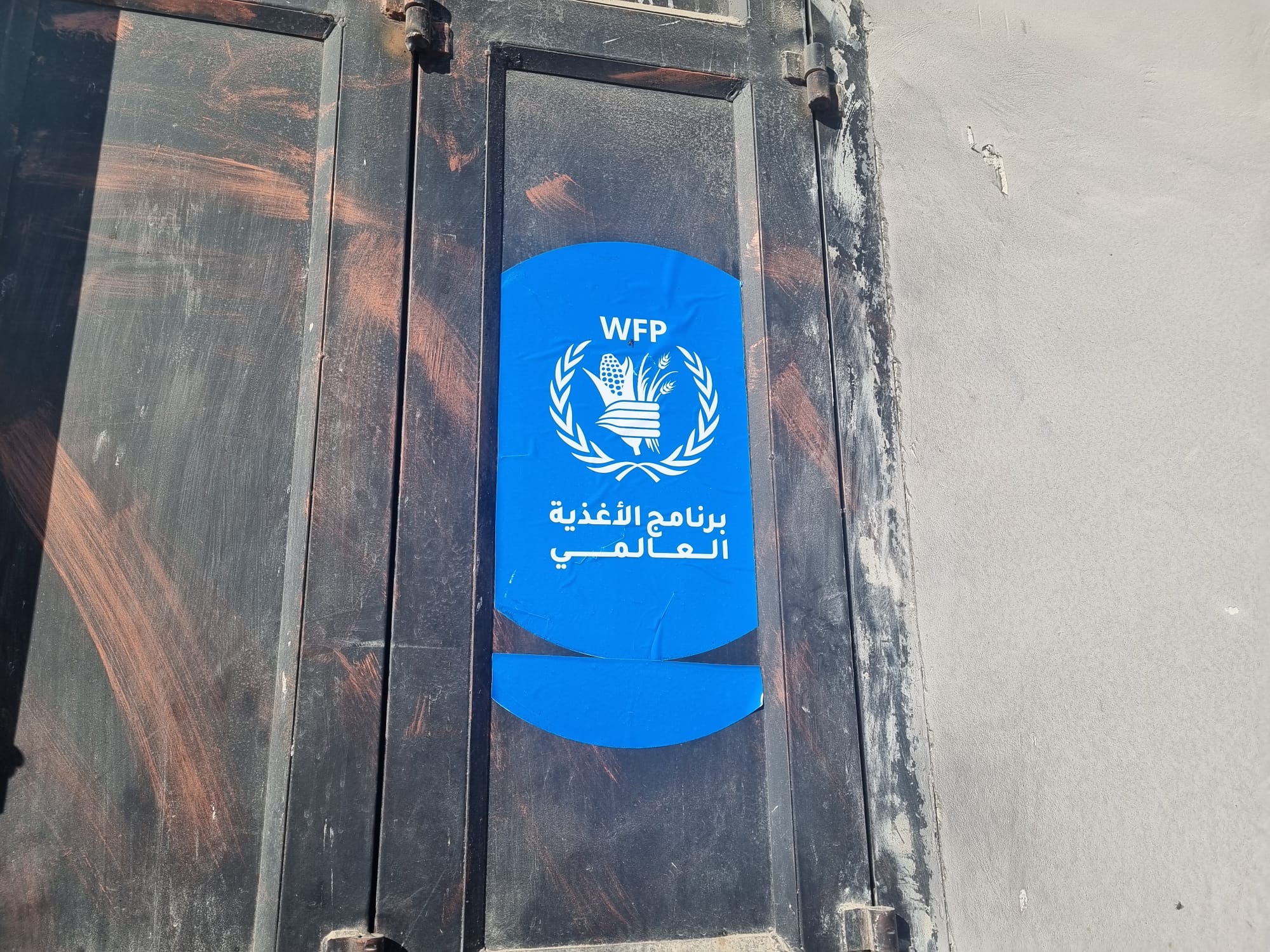 מדבקה של אירגון האוכל העולמי (WFP) בכניסה למכולת בתוואני