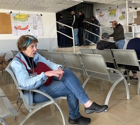 מת"ק עציון - שלומית יושבת באולם המתנה מאחוריה קרוסלות חשוכות 