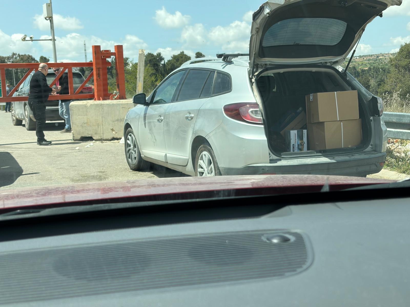 Beit Ummar. Transferring goods in a back-to-back manner near the closed gate