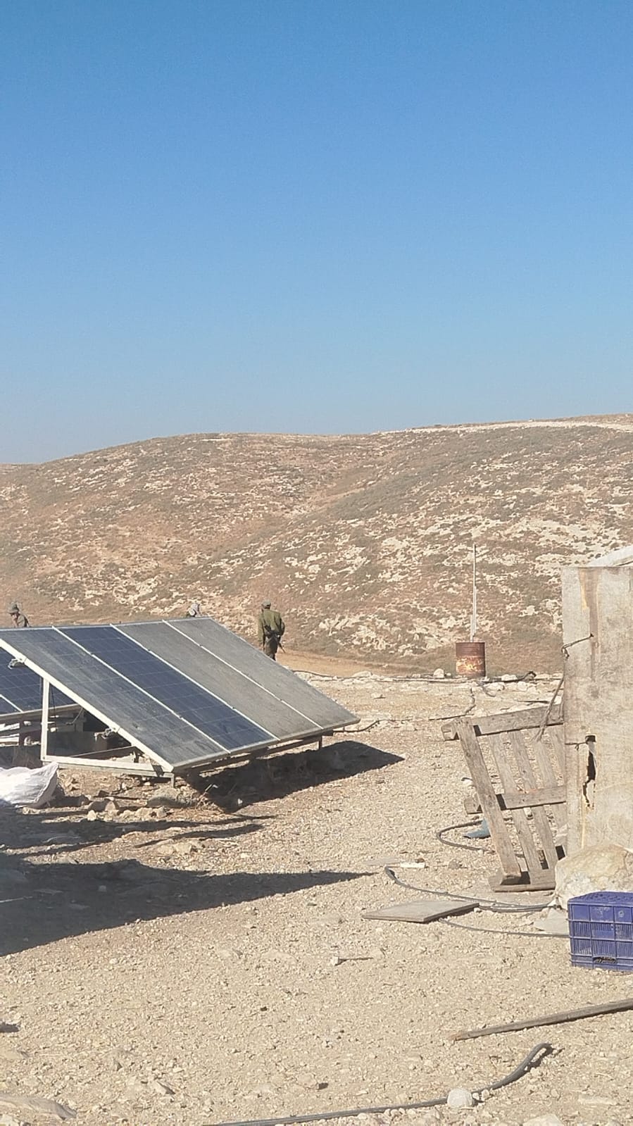 1 - A settler walks around the compound in military uniform