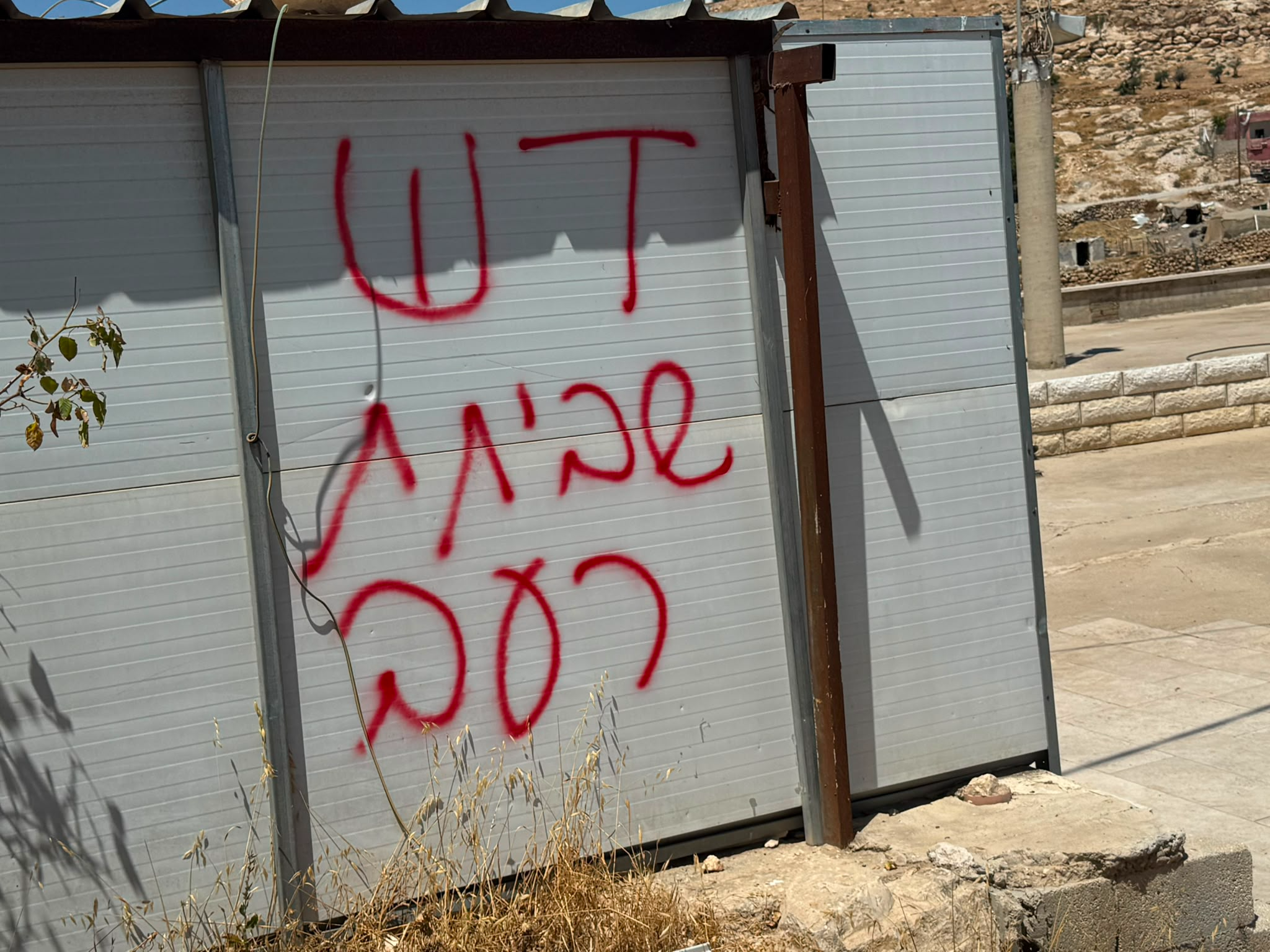 גרפיטי שכתבו מתנחלים שביצעו את הפוגרום בתוואני