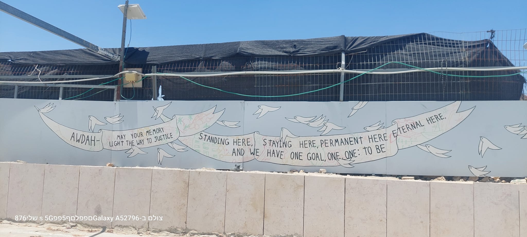 The large inscription on the wall in the courtyard of the Umm al-Khair community center