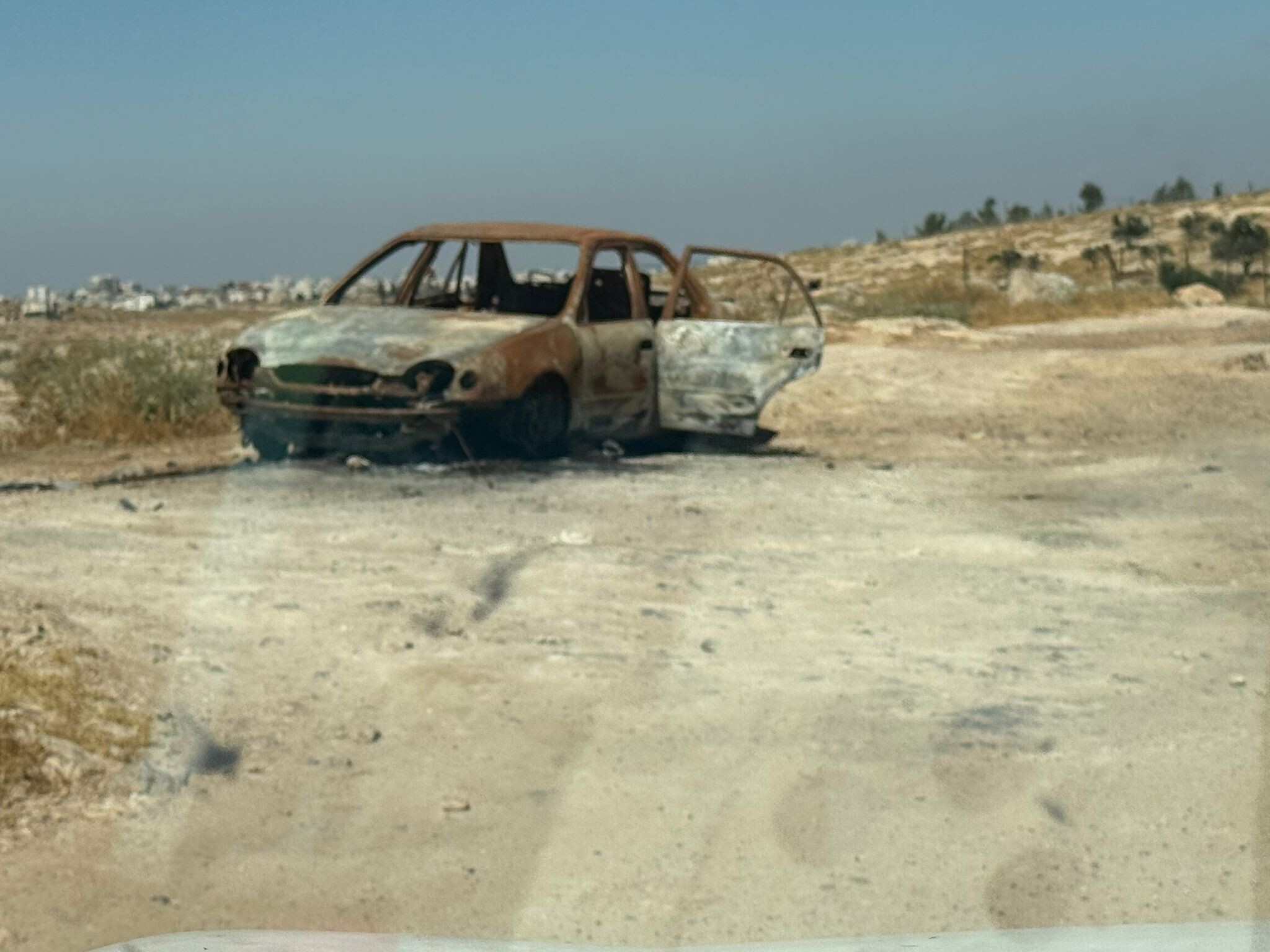 The stolen car that the settlers left in the yard and burned