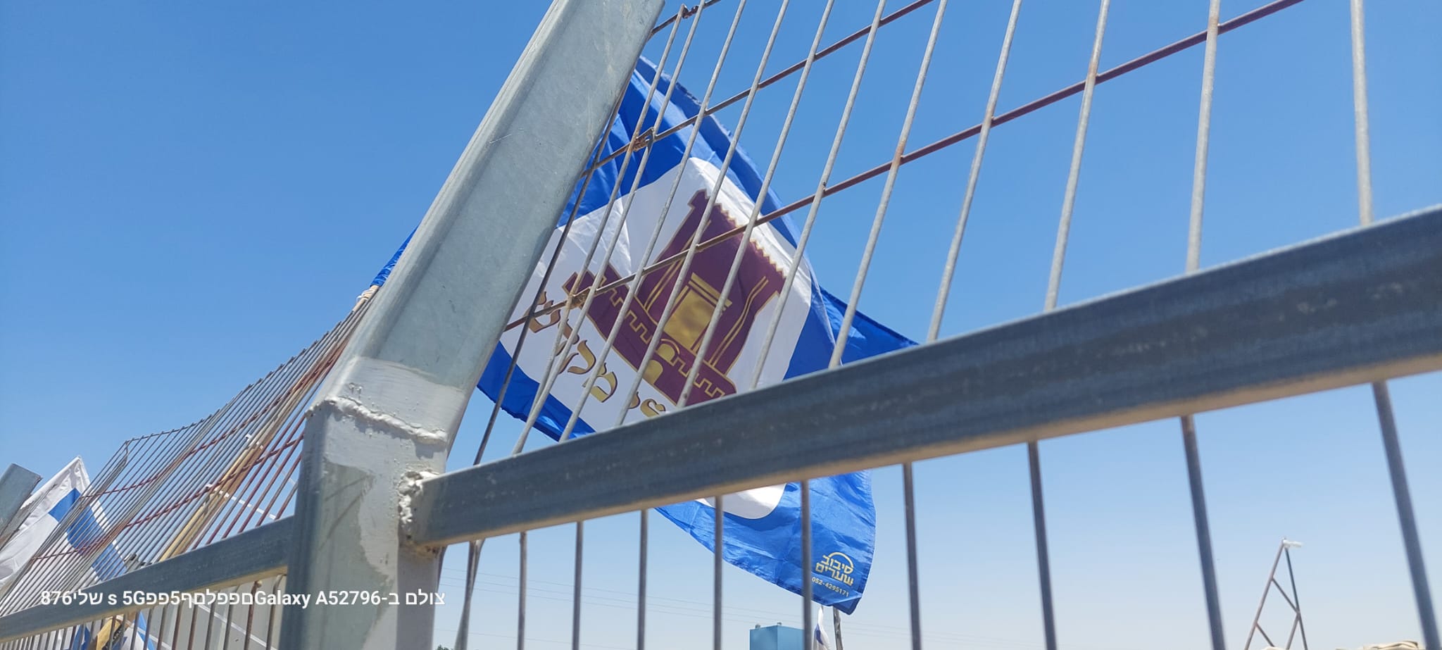 Carmel children, backed by adults, come from the direction of the Barkai neighborhood that is currently being built and hang Israeli flags on the houses of Umm al-Khair.