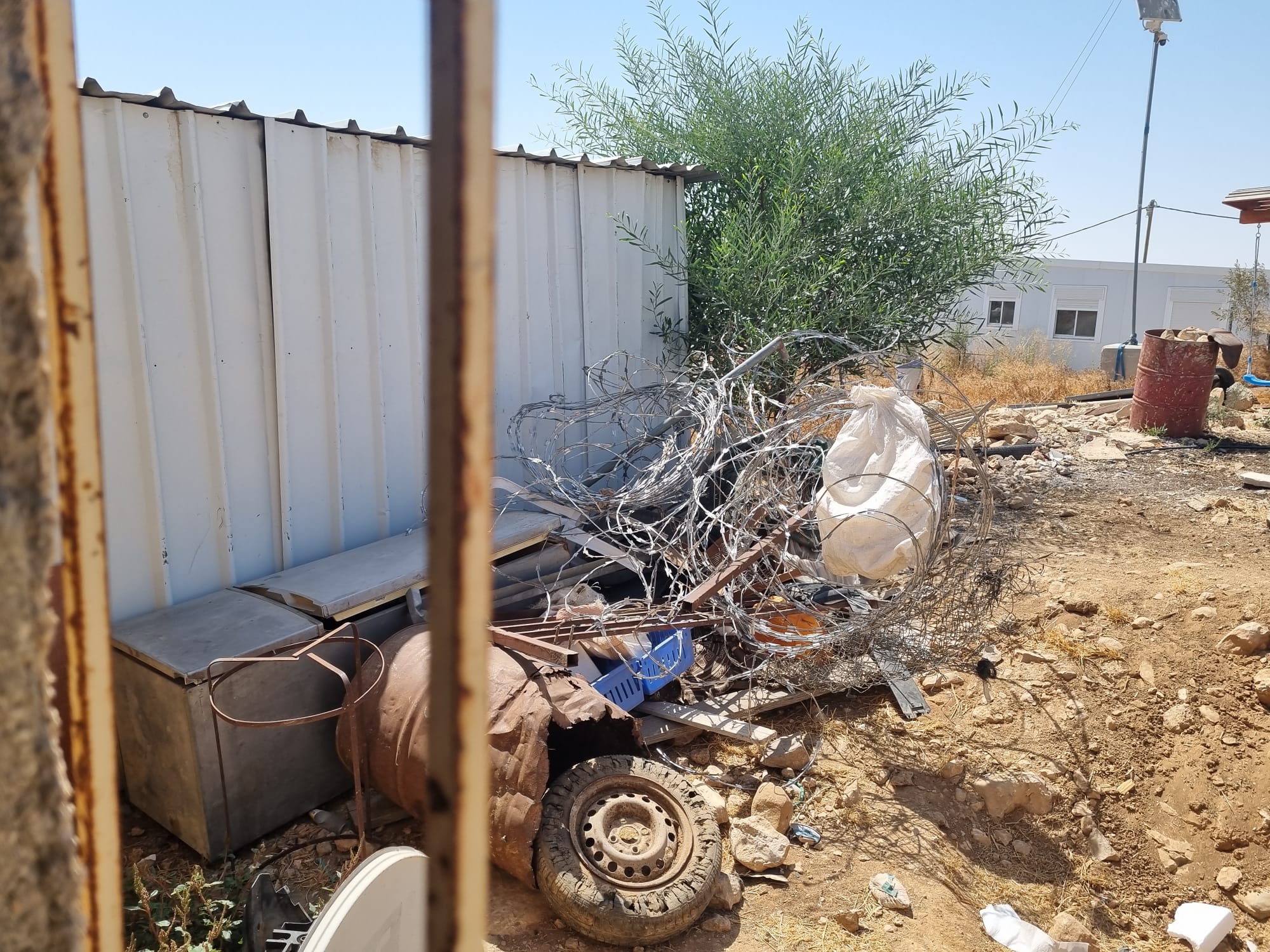 A barbed wire fence placed near the Salem Hadalin family's toilet by settlers prevents use of the toilet.