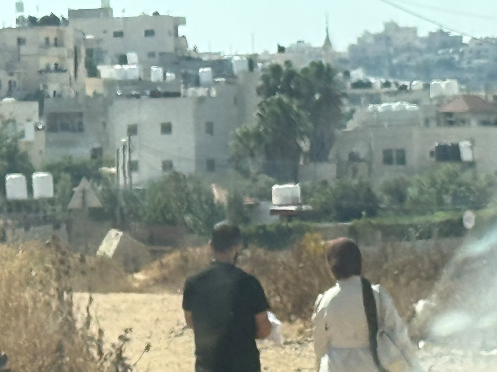 זוג צעיר עם תינוק הולכים ברגל בצומת דורא-אל-פוואר
