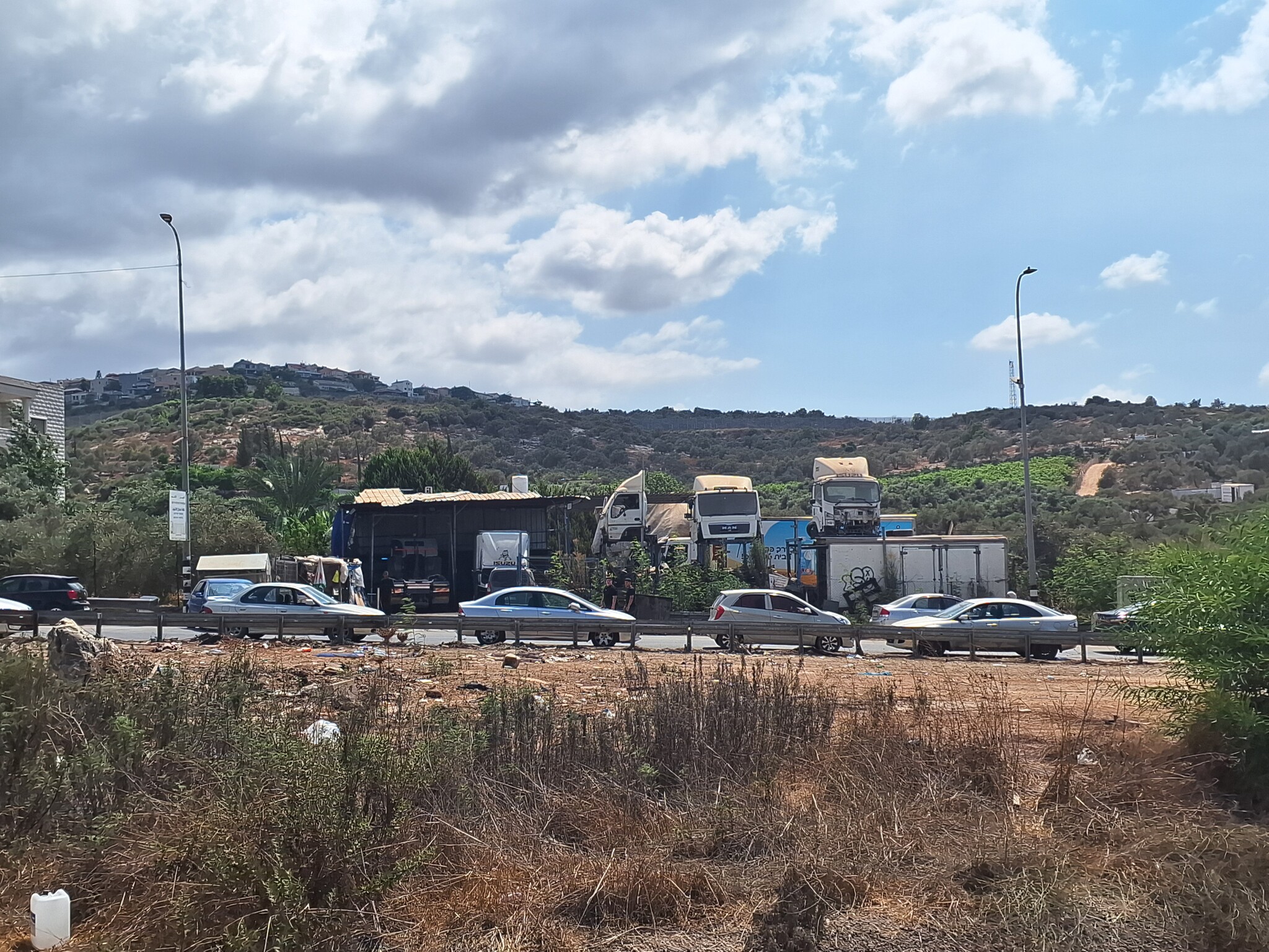 נבי אליאס. מכוניות חונות לאורך הכביש בכניסה לכפר 