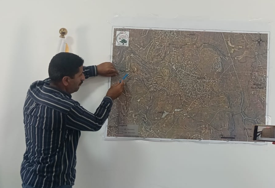 Qusra. The mayor explaining on the map