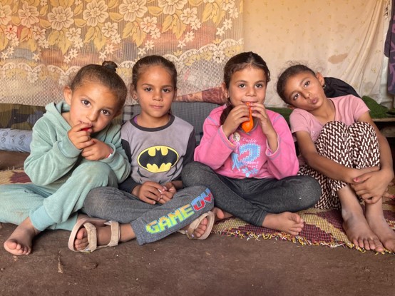 Khirbet Humsa, Jordan Valley: young girls sculpt with clay and blow up balloons for fun